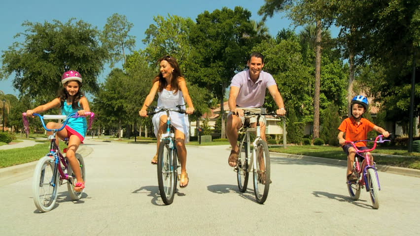 Attractive healthy caucasian family enjoying keeping fit together cycling outdoors 60FPS