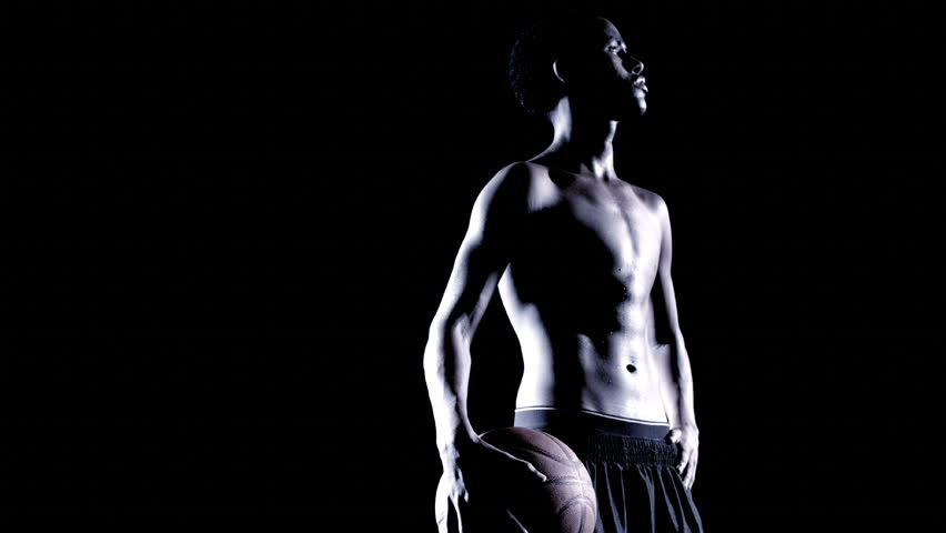 An African man dribbles a basket ball.