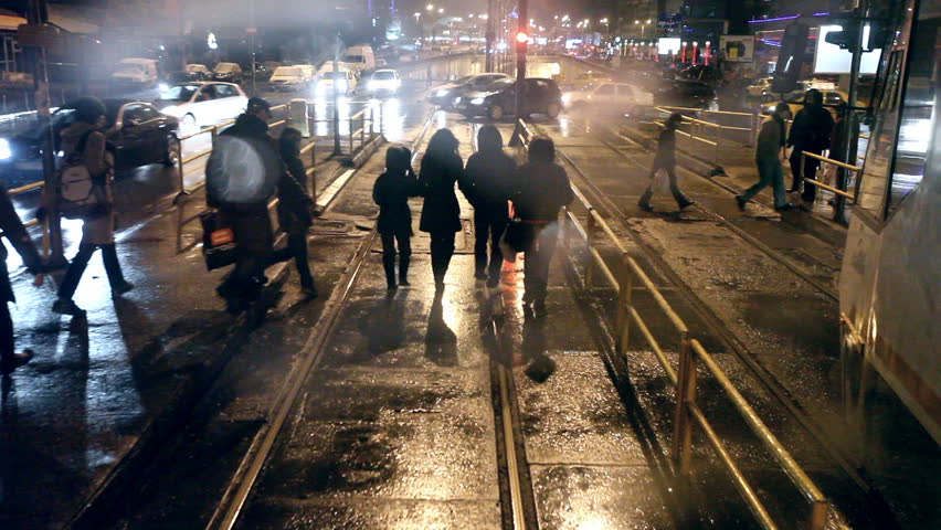 Tram's steamy rear window view. Cold weather cityscape. Night time. Exterior focus. Tunnel passing. 