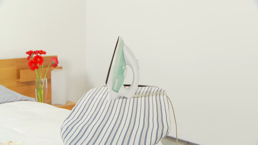 Young woman ironing clothes in a hurry