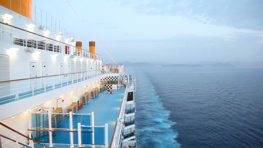boy walks on cruise ship at night.