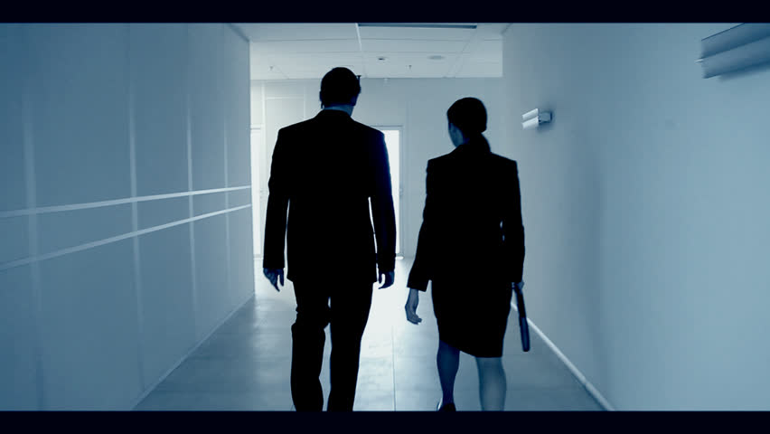 Back view of man and woman going along hallway and coming in light room with chair