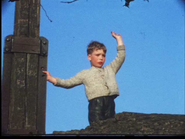 Boy waves goodbye from summit of mountain (vintage 8 mm amateur film)