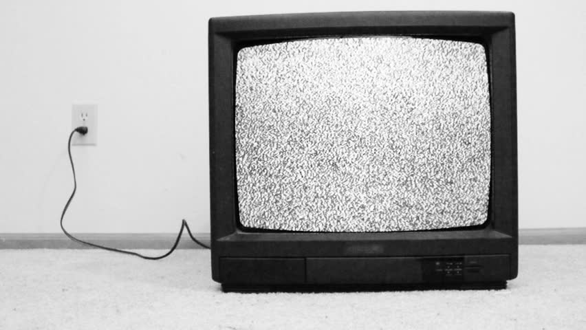 An old television from the 80's turned on with only static appearing on the screen,
