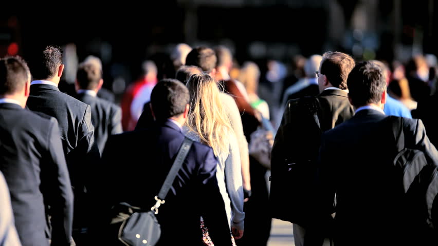 Morning commuters walking to work in a busy city environment with traffic