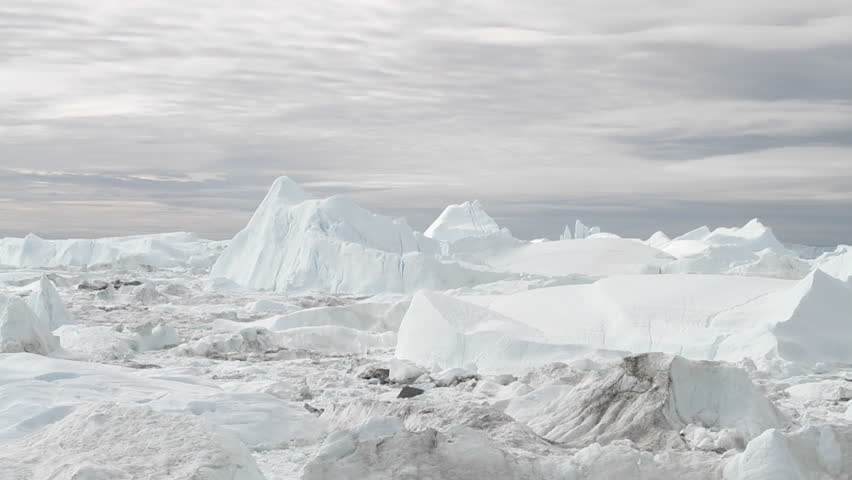 View over Ilulissat icefjord in Greenland. The icefjord is on UNESCO's World Heritage List. The sky is seen moving over head at 40 times normal speed.