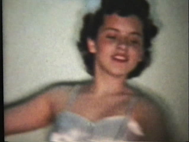 A beautiful teenage ballerina performs her special ballet dance at a recital.