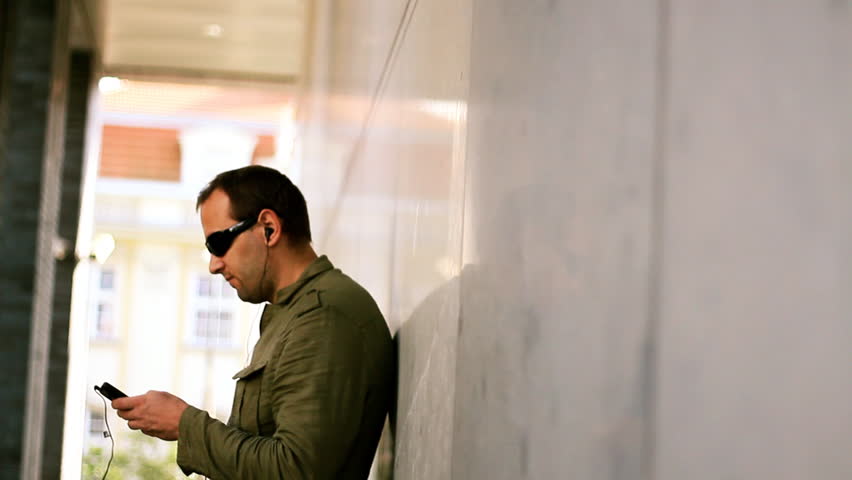 Man in sunglasses listening to music, dolly shot 