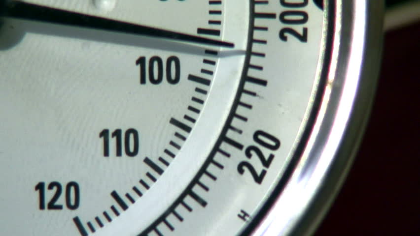 A close-up of a thermometer needle going to the boiling point. Concept of reaching your boiling point or getting mad.