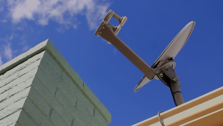 Time Lapse, Clouds roll across television satellite dish mounted on residential rooftop next to chimney. 1080p