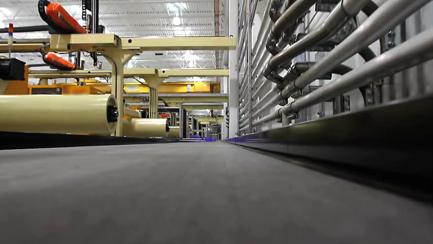A first person perspective shot riding the conveyor belt as robotic arms drop products onto it. 