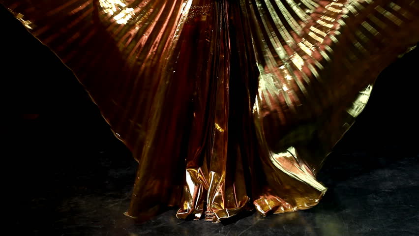 Arabic dancer with gold wing looks at camera 