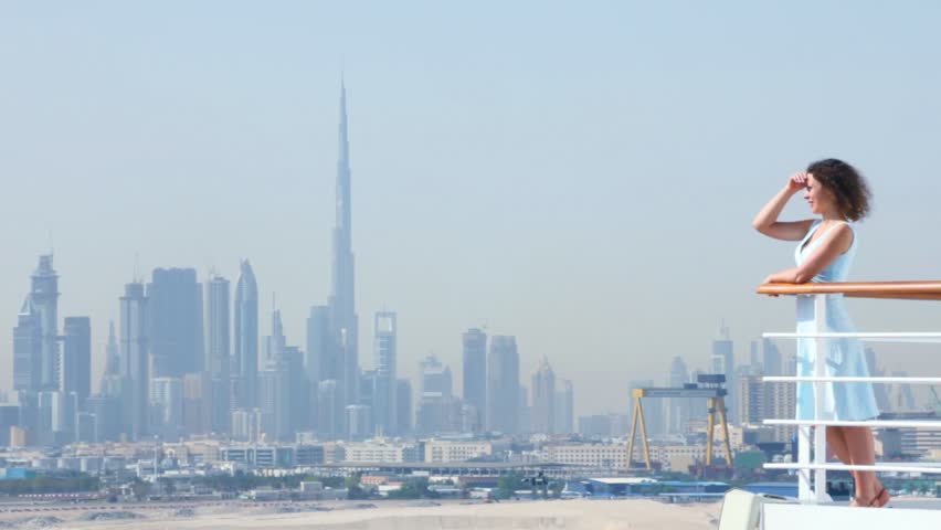 young beautiful woman is standing on the deck at railing in Dubai