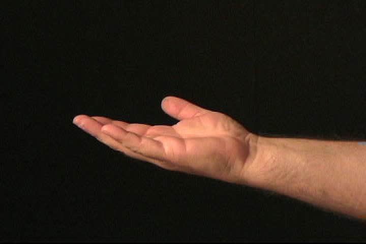 Coins fall onto an open hand against a black background.  The hand makes the "thumbs up" sign