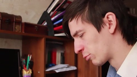 young guy has a runny nose, wipes his nose with a handkerchief, sneezes into his handkerchief
