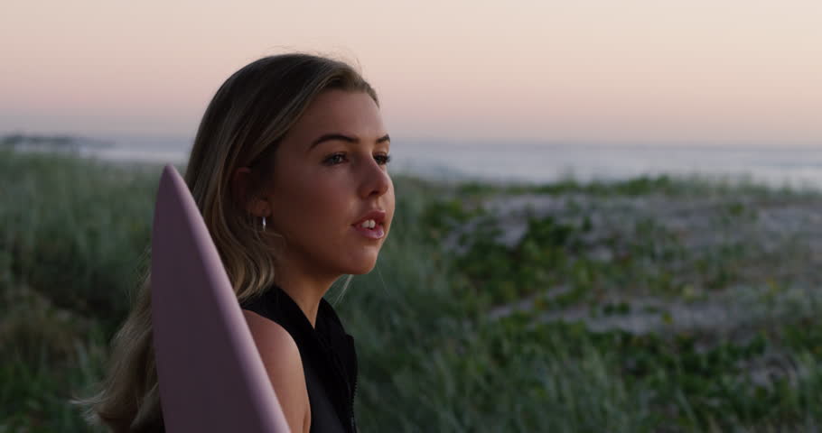 Attractive girl looking out at the sunset over the ocean. Shot with a RED camera. 4k footage.