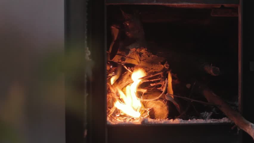 Lighting The Fireplace At Home Shoot Of Hands Adding Paper To The Fire