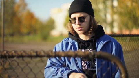 Handsome Guy With Sunglasses A Handsome Man Posing In Front Of The Camera A Guy With Long Hair Shows Emotion Teenager Behind The Cage