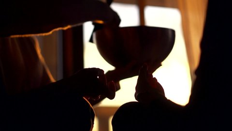 monks are holding sacred tibetan singing bowl and master is touching it by mallet, meditating
