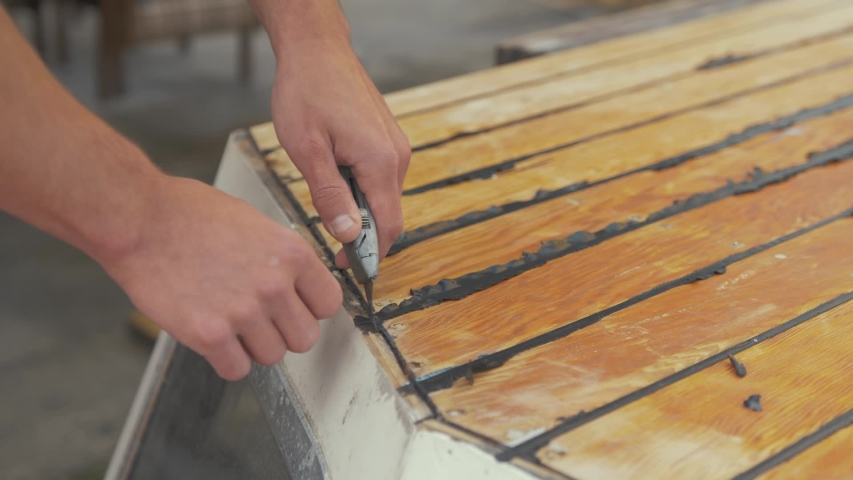 Trimming Mastic Flashing Excess On Cabin Roof Planking Of Wooden