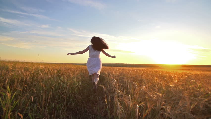 A young girl happily running through a field of… - Royalty Free Video