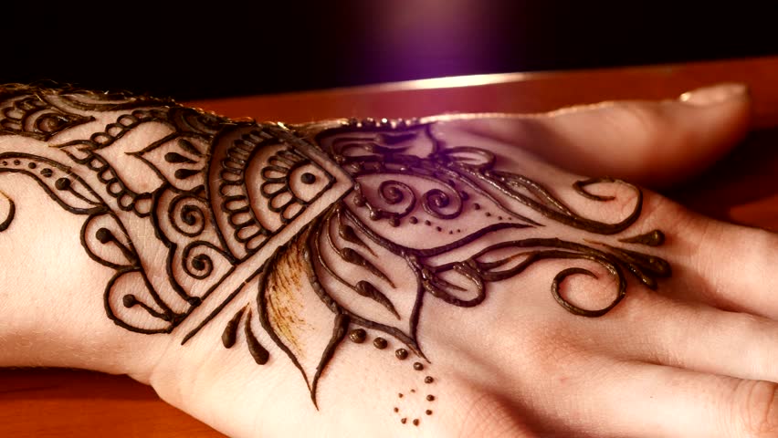 woman hand being decorated with henna tattoo mehendi on black woman hand being decorated with henna tattoo mehendi on black
