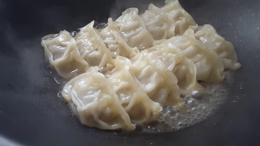 Close Up Cooking Fried Dumplings In A Frying Pan Chinese Food With Hot Steams Close Up Cooking Fried Dumplings In A Frying Pan Chinese Food With Hot Steams
