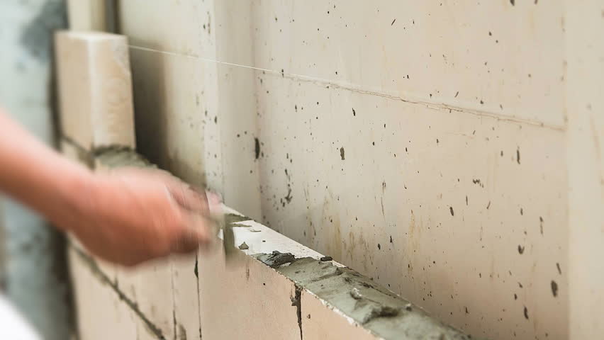 4K. Time lapse construction worker. mason bricklayer installing brick with trowel putty knife