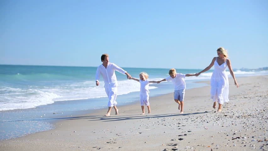 Young Caucasian Family Holding Hands Walking Along The Beach Stock - 852x480 - jpeg Family Holding Hands Beach