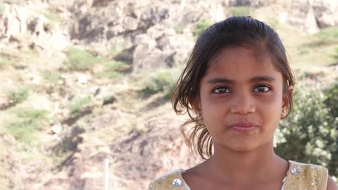 Little cute Indian girl watching something and getting frightened but happy and smiling still