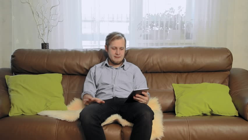 Attractive Young Man On Couch  Watching TV Changing 