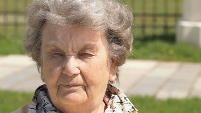 Portrait Of Smiling Mature Old Woman With Gray Hair Aged 80s Outdoors