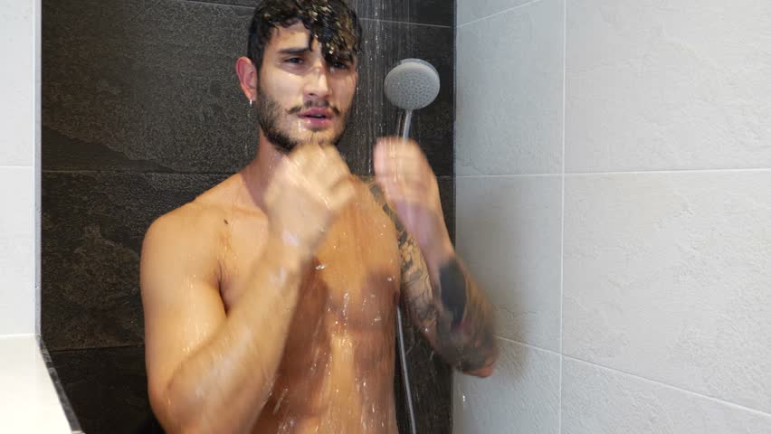Muscly guy in tats showering