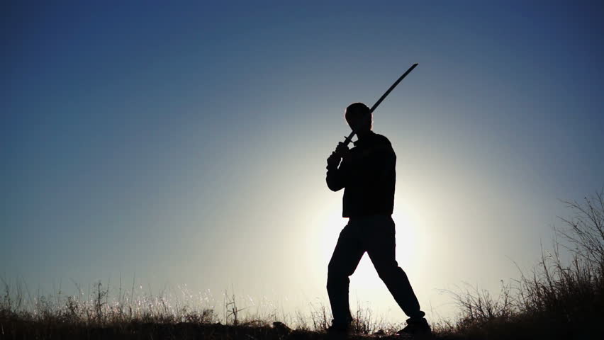 An Asian Man In A Japanese Gi Draws A Samurai Sword (Katana), And ...