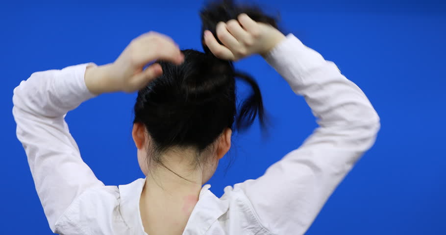 Girl Putting Her Hair Up With Pencil Pencil Bun