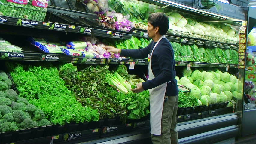 Worker Inspecting Produce Display Of Fresh Green Beans In Grocery Store ...