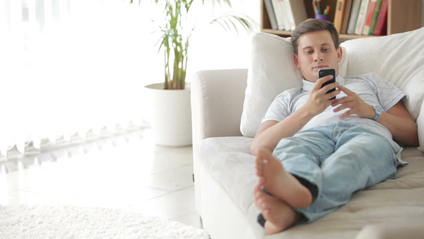 Hd00 28attractive Young Man Lying On Sofa With Cellphone And Smiling Attractive Young Man Lying On Sofa With Cellphone And Smiling
