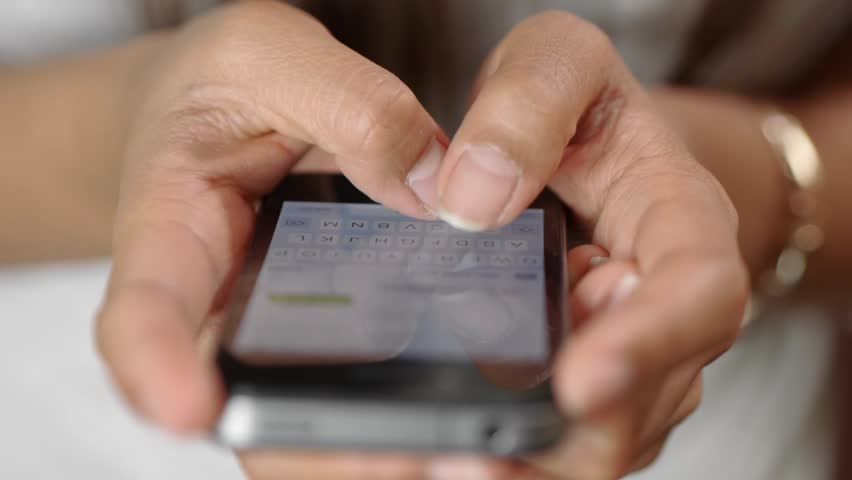 Texting woman on a iPhone smartphone device.