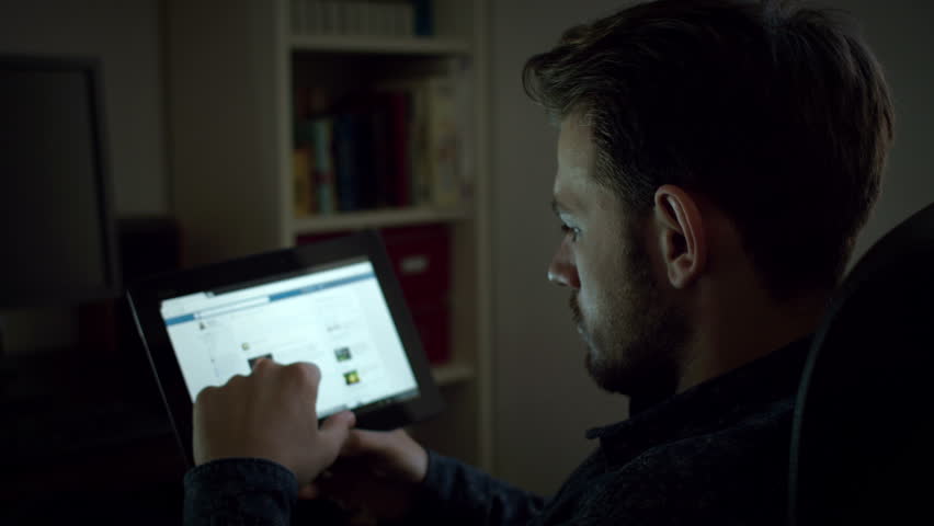 Dark Living Room At Night guy with tablet computer in the dark room. social network Dark Living Room At Night guy with tablet computer in the dark room. social network